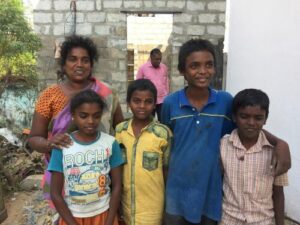 Witwe und ihre Kinder freuen sich auf ihr neues Haus (im Hintergrund Om Shanthi-Geschäftsführer Manoharan Mannupillai)