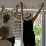 2 Frauen hängen "Happy Birthday" auf