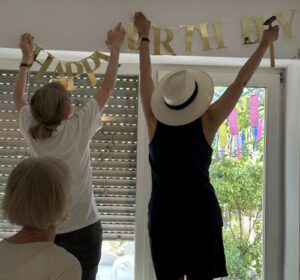 2 Frauen hängen "Happy Birthday" auf